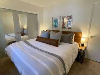 This cozy bedroom features a comfortable bed with stylish bedding and decorative pillows.