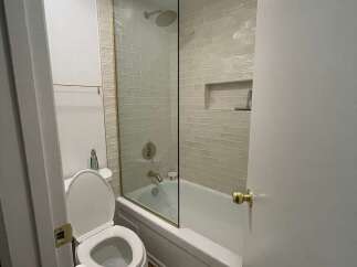 Step into this beautifully designed bathroom featuring a modern glass shower enclosure and elegant tile work.