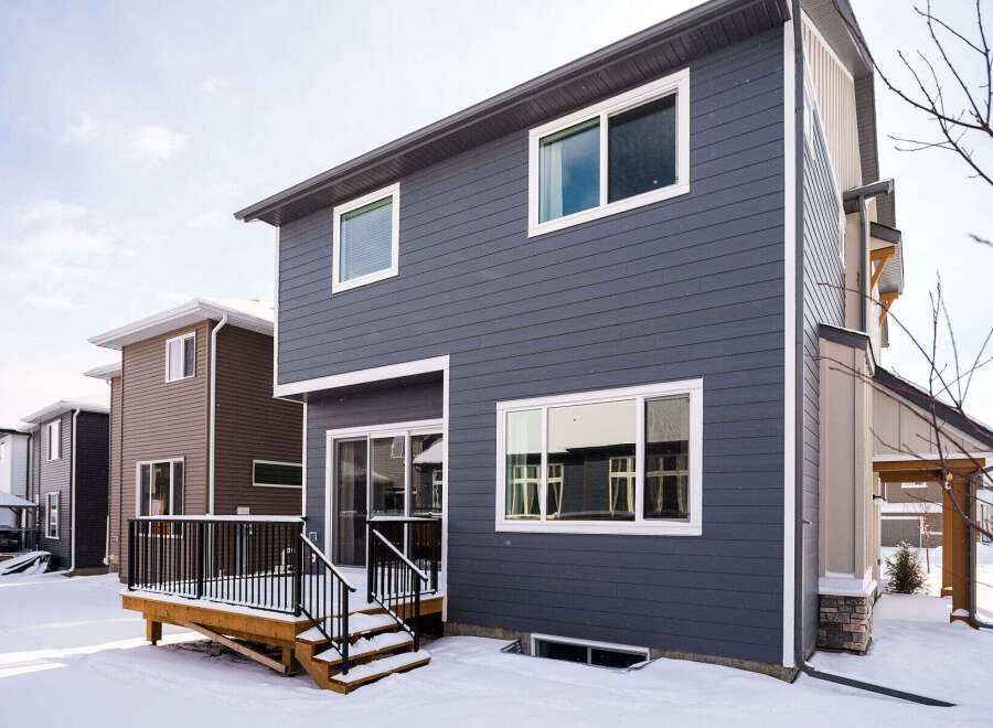 This stunning property boasts a modern exterior with sleek siding and large windows, offering ample natural light.
