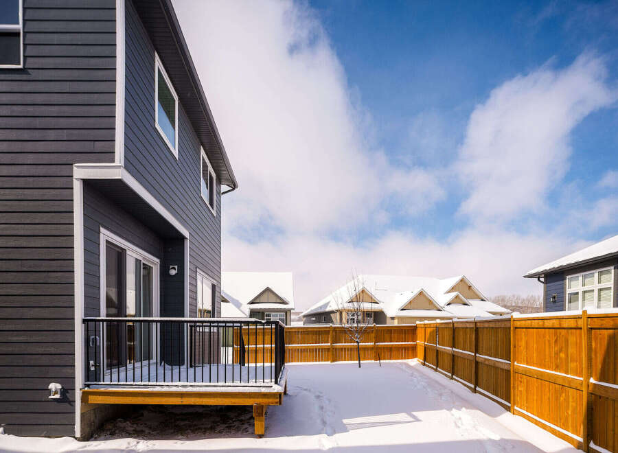 This stunning property boasts a modern exterior with dark siding and a beautifully designed deck.