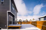 This stunning property boasts a modern exterior with dark siding and a beautifully designed deck.
