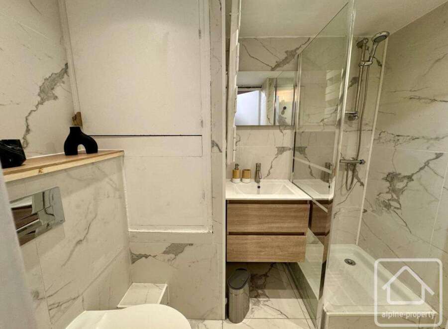 This modern bathroom features elegant marble tiling and a sleek design.