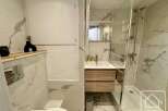 This modern bathroom features elegant marble tiling and a sleek design.