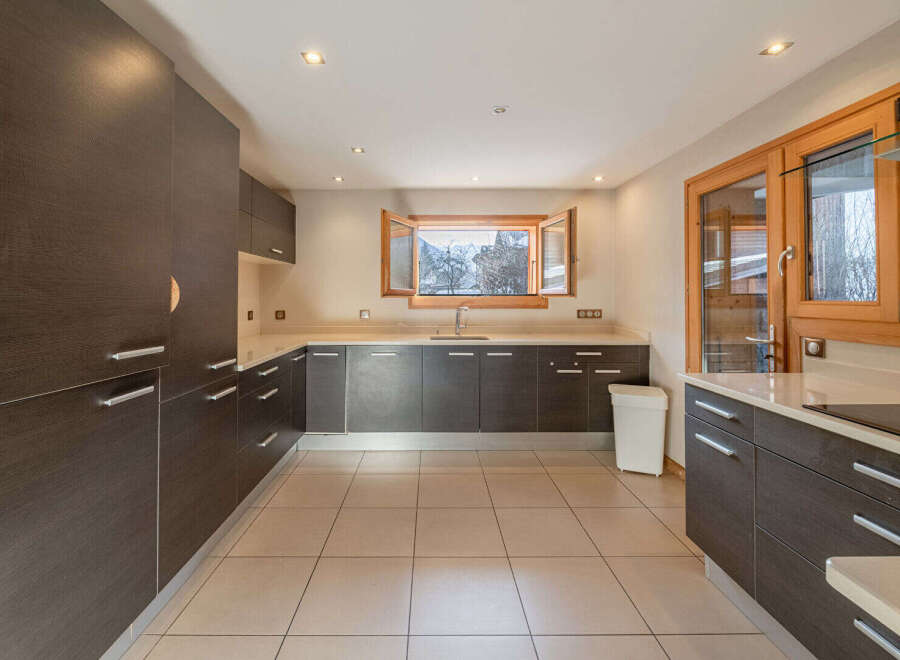 This modern kitchen boasts sleek, dark wood cabinetry and ample storage space.