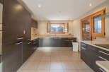 This modern kitchen boasts sleek, dark wood cabinetry and ample storage space.