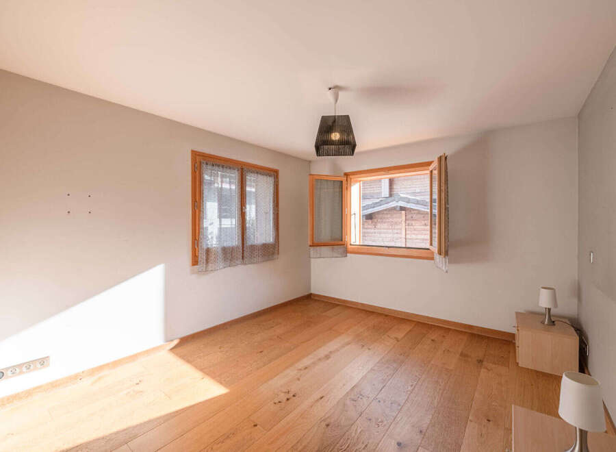 This charming room features beautiful wooden floors and ample natural light, creating a warm and inviting atmosphere.