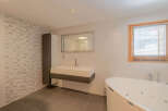 This modern bathroom features a sleek design with a floating vanity and a luxurious soaking tub.