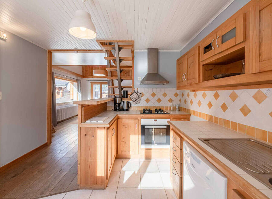 This charming kitchen boasts a warm, inviting atmosphere with its wooden cabinetry and tiled backsplash.