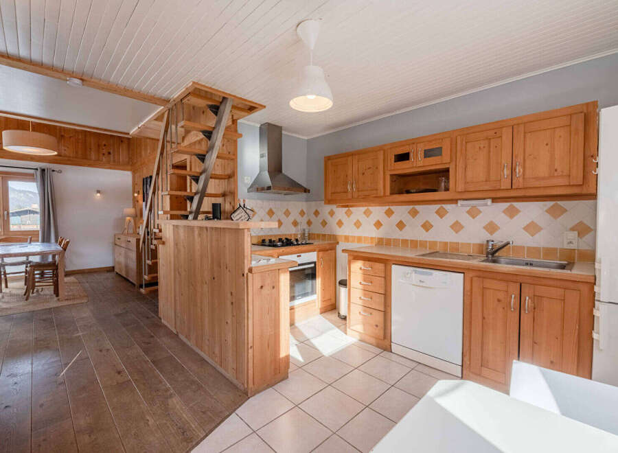 Discover this charming property featuring a cozy kitchen with wooden cabinetry and a modern dishwasher.