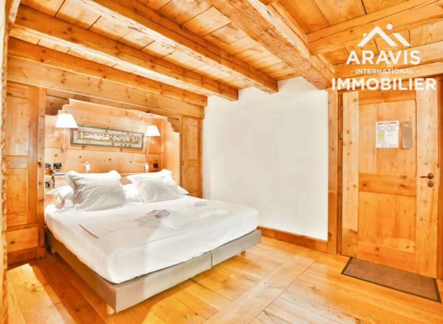 This stunning bedroom boasts a rustic charm with its wooden beams and paneling, creating a warm and inviting atmosphere.