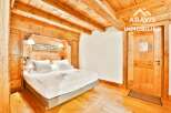 This stunning bedroom boasts a rustic charm with its wooden beams and paneling, creating a warm and inviting atmosphere.