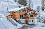 Nestled in a snowy landscape, this charming wooden chalet offers a cozy retreat.