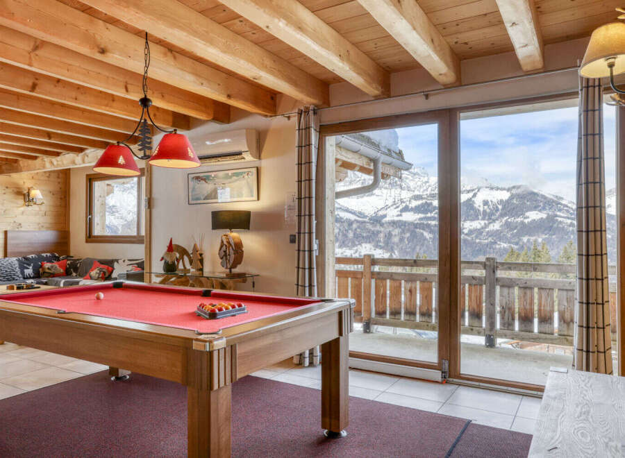 Experience the ultimate mountain retreat in this stunning property, featuring a cozy interior with a pool table, perfect for entertaining guests.