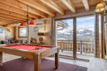 Experience the ultimate mountain retreat in this stunning property, featuring a cozy interior with a pool table, perfect for entertaining guests.