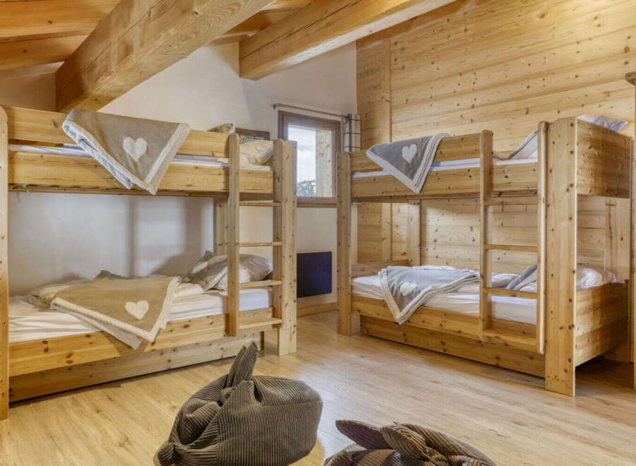 This cozy bedroom features two sets of wooden bunk beds, perfect for accommodating multiple guests or family members.
