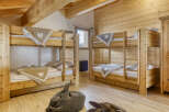 This cozy bedroom features two sets of wooden bunk beds, perfect for accommodating multiple guests or family members.