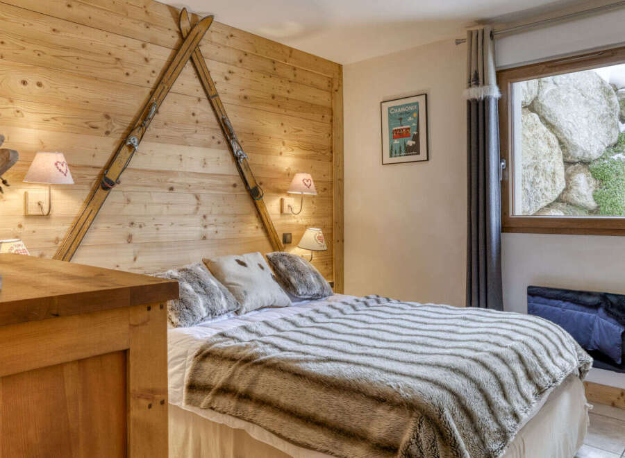 Experience the charm of this cozy bedroom, featuring a unique wooden wall adorned with vintage skis.