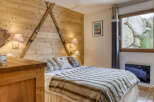 Experience the charm of this cozy bedroom, featuring a unique wooden wall adorned with vintage skis.