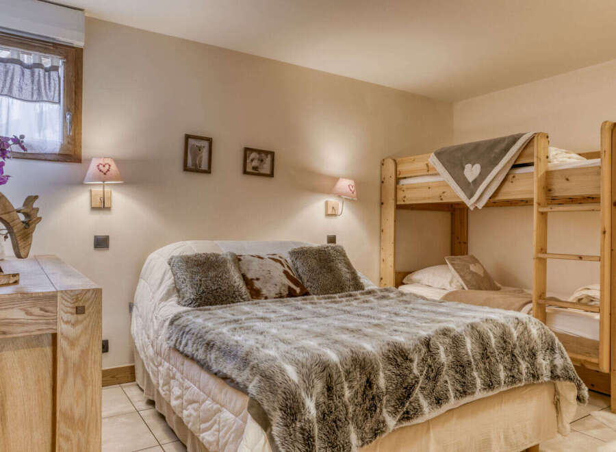 This cozy bedroom features a comfortable bed with a faux fur throw and decorative pillows, perfect for a relaxing stay.