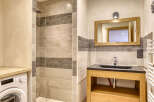 This stunning bathroom features a modern design with a sleek black countertop and a wooden vanity.