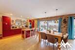 This stunning property boasts a modern kitchen with sleek red cabinetry and a central island, perfect for culinary enthusiasts.