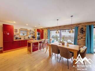 This stunning property boasts a modern kitchen with sleek red cabinetry and a central island, perfect for culinary enthusiasts.