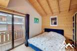 Discover the charm of this cozy bedroom featuring a wooden ceiling and walls, creating a warm and inviting atmosphere.
