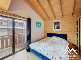 Discover the charm of this cozy bedroom featuring a wooden ceiling and walls, creating a warm and inviting atmosphere.