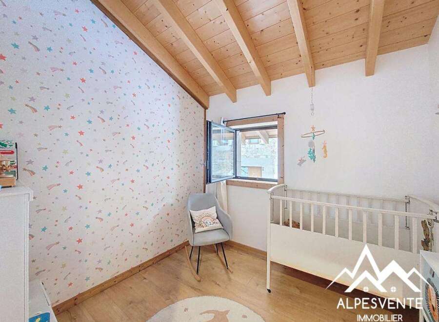 Discover a charming nursery with a whimsical star-patterned wallpaper and a cozy wooden ceiling.