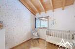 Discover a charming nursery with a whimsical star-patterned wallpaper and a cozy wooden ceiling.