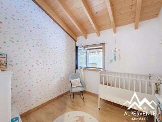Discover a charming nursery with a whimsical star-patterned wallpaper and a cozy wooden ceiling.