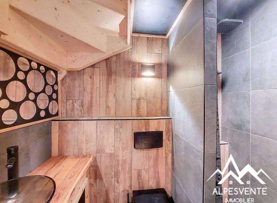 Discover the charm of this unique property, featuring a beautifully designed bathroom with a modern shower and stylish wooden accents.