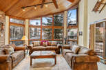 Experience luxury living in this stunning property, featuring a cozy living room with a unique wooden ceiling and expansive windows that offer breathtaking views of the surrounding landscape.