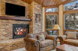 Experience the warmth of this inviting living space, featuring a cozy fireplace and exposed brick accents.