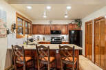 Step into this inviting kitchen, featuring warm wooden cabinetry and a stylish breakfast bar perfect for casual dining.