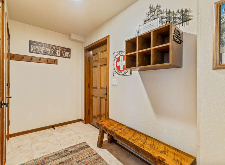 This inviting entryway features a rustic wooden bench, perfect for removing ski boots after a day on the slopes.