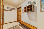 This inviting entryway features a rustic wooden bench, perfect for removing ski boots after a day on the slopes.