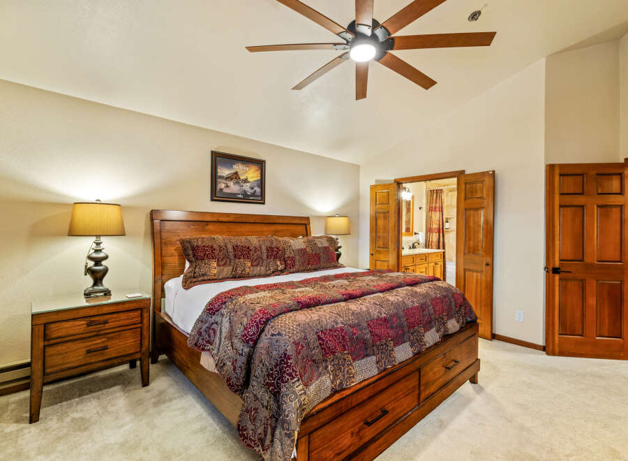 This stunning bedroom features a luxurious wooden bed frame and matching nightstands, creating a warm and inviting atmosphere.