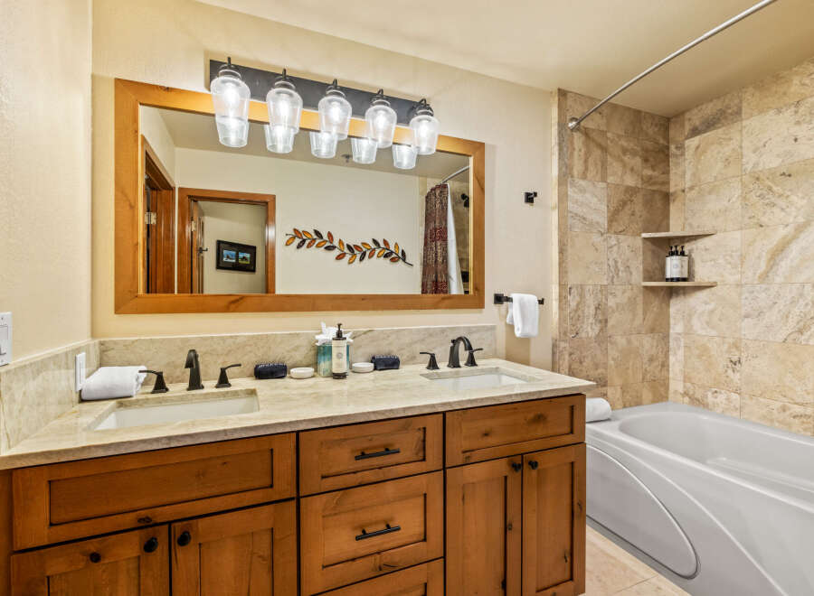 This luxurious bathroom boasts a double vanity with a stunning marble countertop and elegant black fixtures.