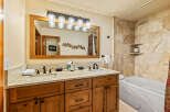 This luxurious bathroom boasts a double vanity with a stunning marble countertop and elegant black fixtures.
