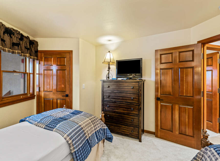 This cozy bedroom features a rustic charm with its wooden doors and trim.