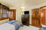 This cozy bedroom features a rustic charm with its wooden doors and trim.
