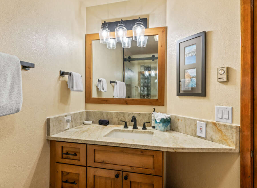 This stunning bathroom boasts a rustic charm with its wooden vanity and elegant countertop.