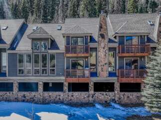 Discover the charm of this stunning mountain property, featuring a beautifully designed exterior with stone accents and multiple balconies.