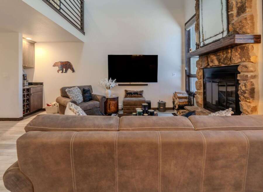 Step into luxury with this stunning living room, featuring a cozy fireplace and a large flat-screen TV perfect for entertaining.