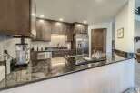 This stunning kitchen boasts dark wood cabinetry, stainless steel appliances, and a sleek cooktop.
