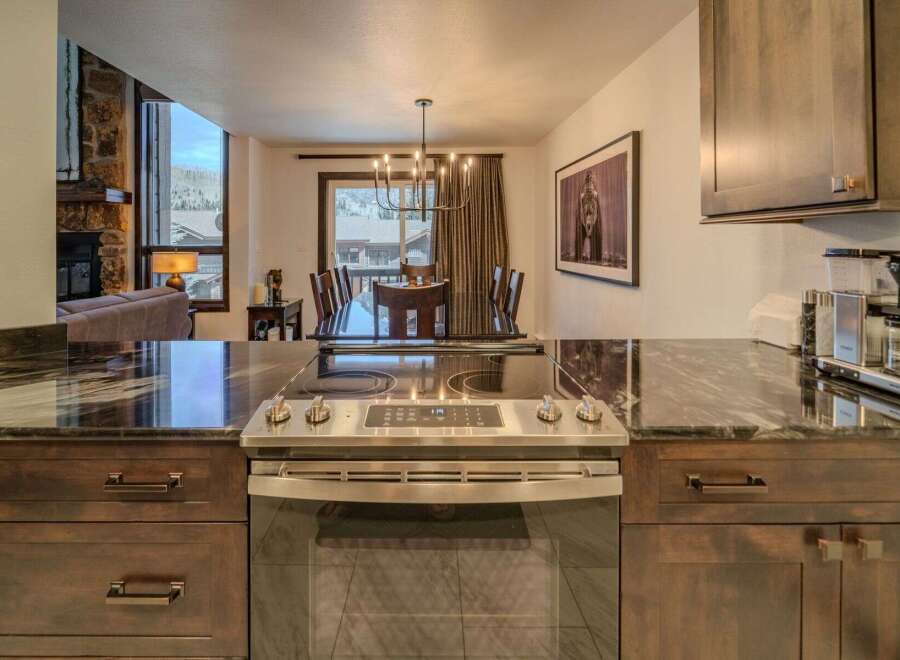 Step into luxury with this stunning kitchen, featuring sleek countertops and modern appliances.