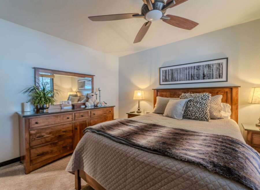 This cozy bedroom features a comfortable bed with a stylish fur throw and decorative pillows.