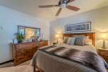 This cozy bedroom features a comfortable bed with a stylish fur throw and decorative pillows.