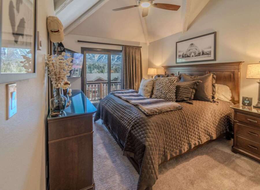 Experience luxury in this stunning bedroom featuring a cozy bed adorned with plush pillows and a warm, inviting comforter.